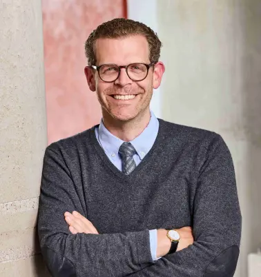 Tobias von Mäßenhausen schaut nach vorne und lächelt. 